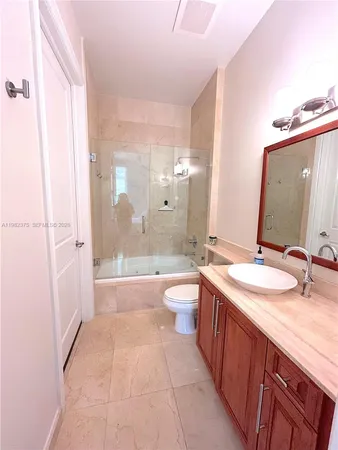 a bathroom with a double vanity sink toilet mirror and bathtub