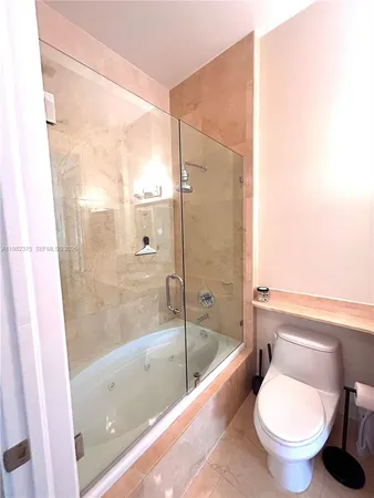 a bathroom with a granite countertop toilet a sink and a bathtub
