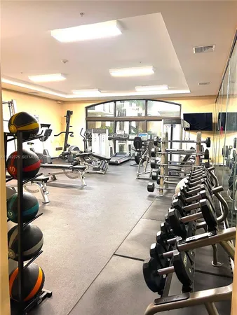 a room with gym equipment and lots of mirrors