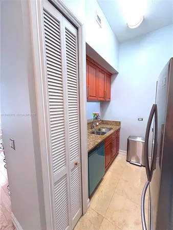 a kitchen with stainless steel appliances granite countertop a refrigerator and a sink