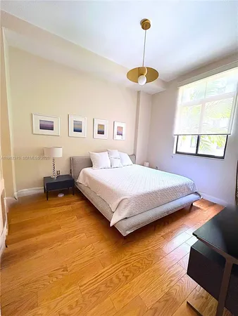 a bedroom with a bed chandelier and a window