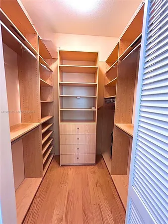 a view of walk in closet with empty racks