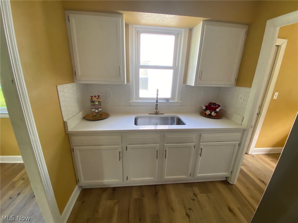 2508 Greenvale Road Cleveland, OH 44121 - Photo 15 of 16 Kitchen featuring light hardwood / wood-style floors, white cabinets, and sink