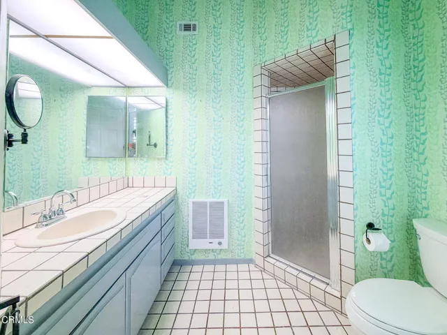 a bathroom with a granite countertop sink toilet and shower