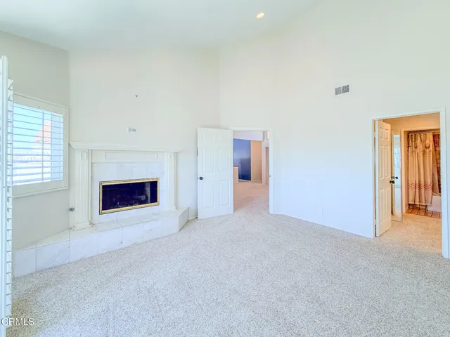 an empty room with windows and fireplace