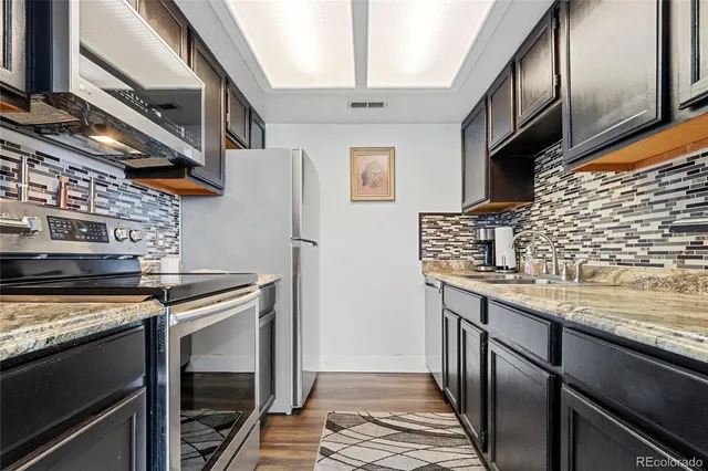 a kitchen with stainless steel appliances granite countertop a stove and a refrigerator