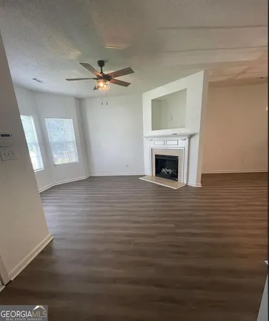 wooden floor fireplace and windows in an empty room