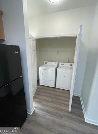 a utility room with wooden floor washer and dryer