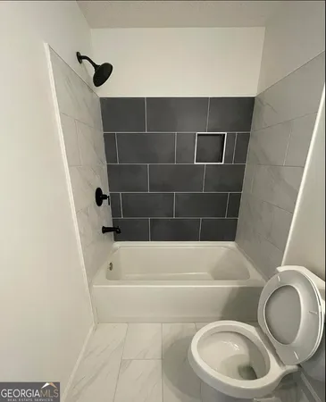 a bathroom with a toilet and bathtub