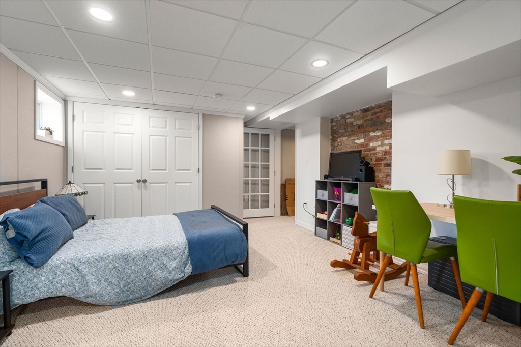 339 Weston Road Wellesley, MA 02481 - Photo 24 of 32 a spacious bedroom with a bed a table and a workspace