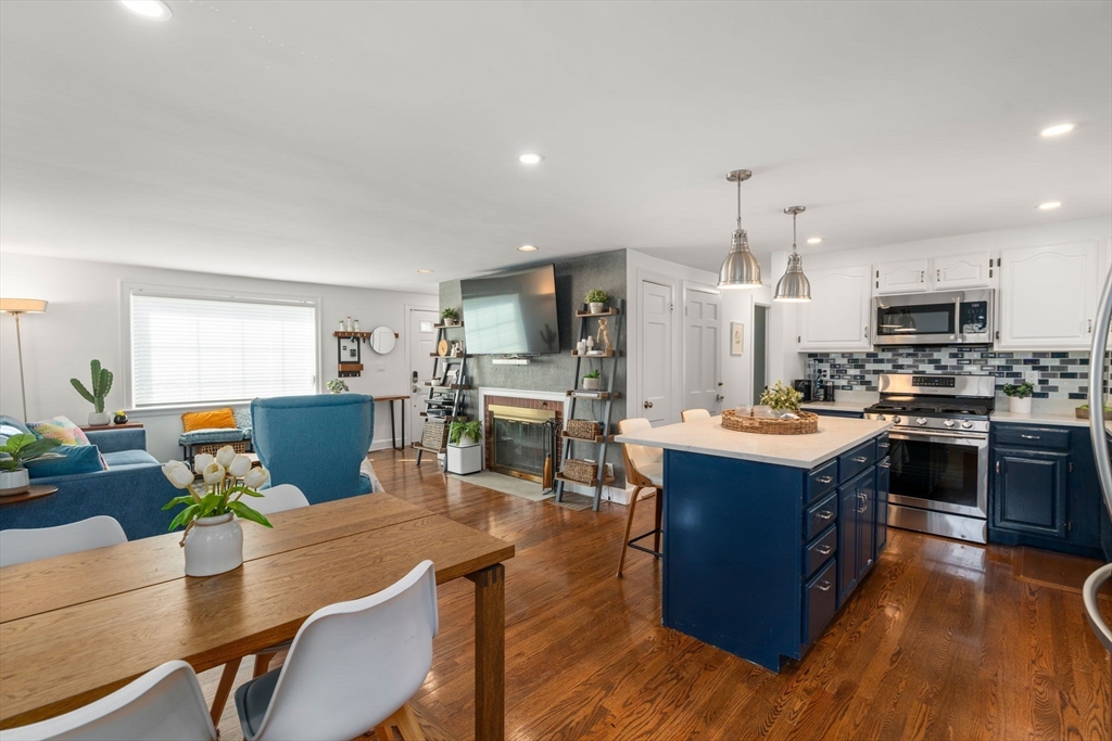 339 Weston Road Wellesley, MA 02481 - Photo 9 of 32 a kitchen with stainless steel appliances granite countertop a stove top oven a sink dishwasher a dining table and chairs with wooden floor