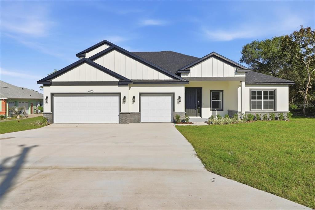 4003 Southwest 102nd Place Ocala, FL 34476 - Photo 1 of 1 a front view of a house with a yard and garage