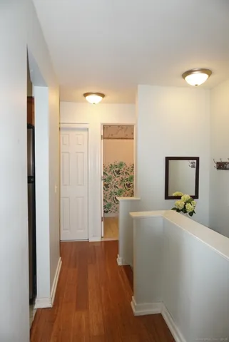 a view of a room that has a bed and mirror in it