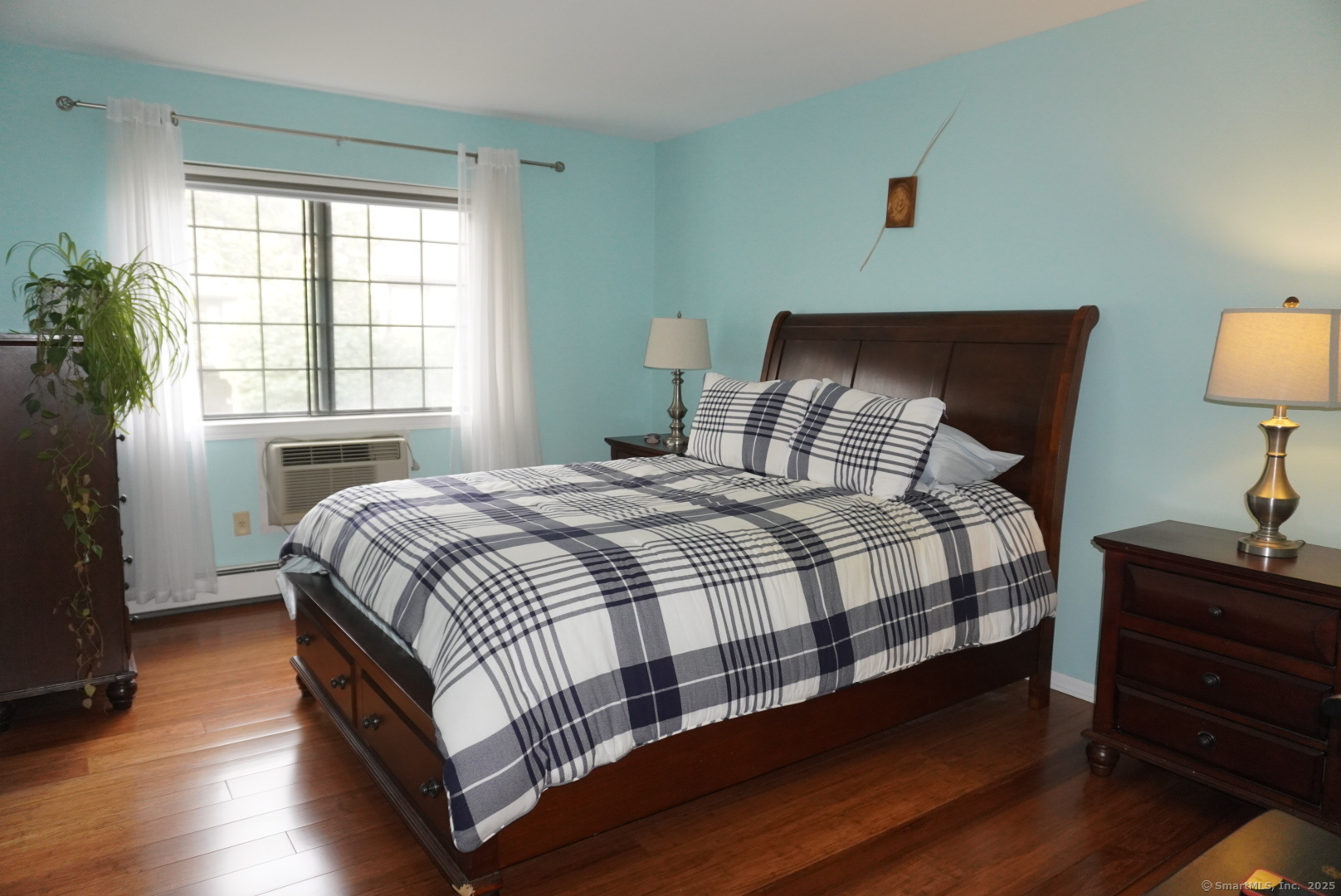 450 Swanson Crescent, Unit 450 Milford, CT 06461 - Photo 7 of 9 a bedroom with a bed and wooden floor