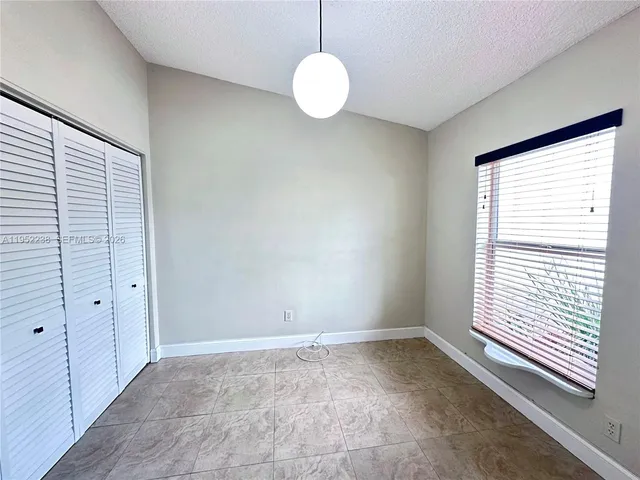 a view of a workspace with a window and dining table in a room