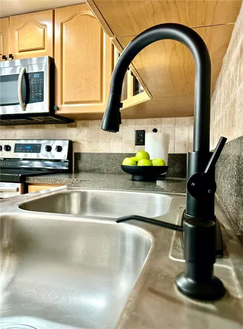 a kitchen with a refrigerator sink and cabinets