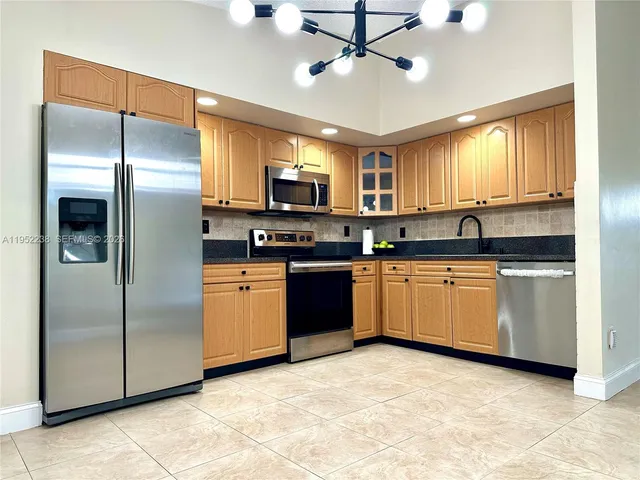 a kitchen with stainless steel appliances granite countertop a stove sink and cabinets