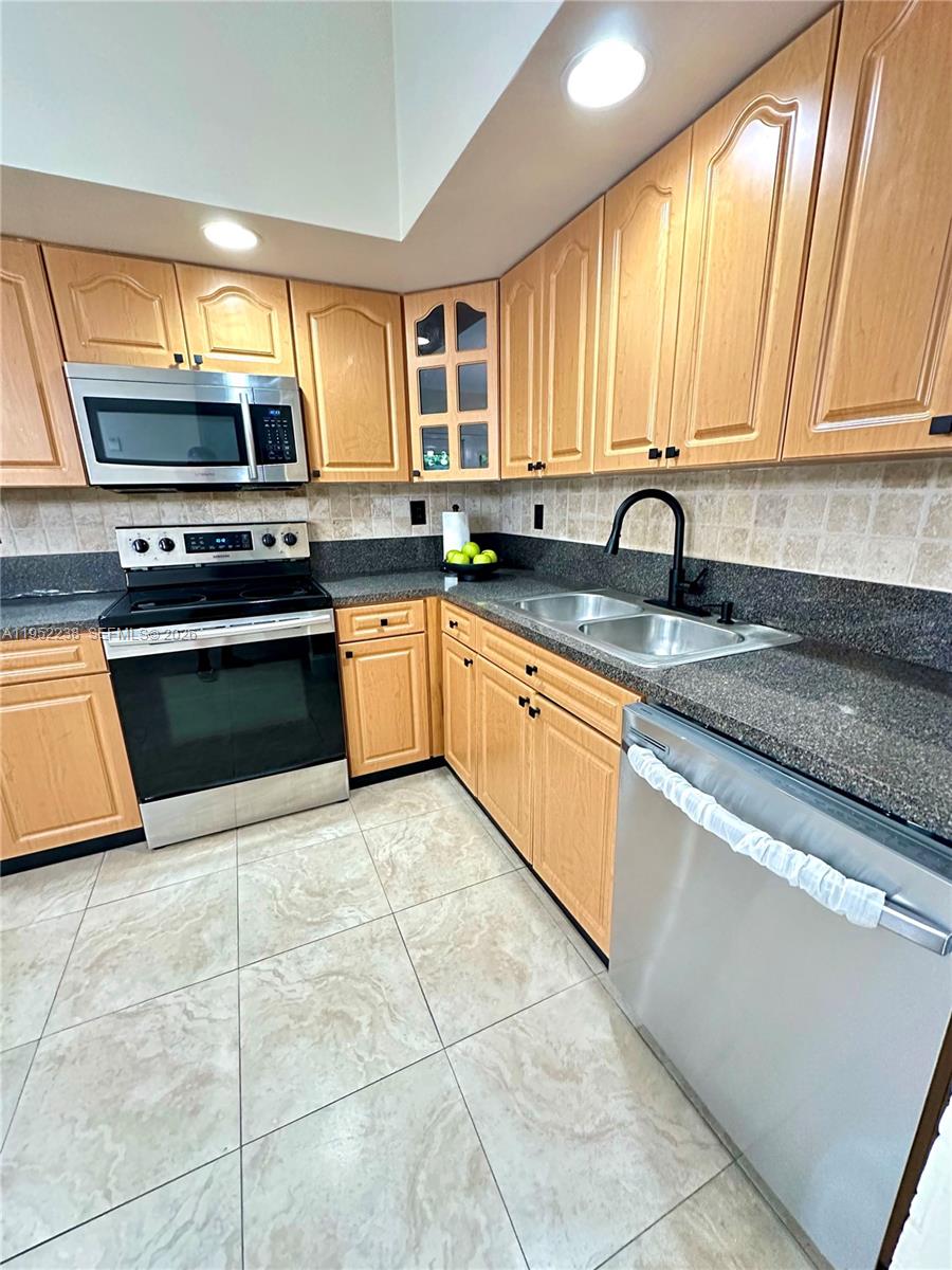 11117 Southwest 122nd Court Miami, FL 33186 - Photo 15 of 29 a kitchen with stainless steel appliances granite countertop a stove sink and cabinets