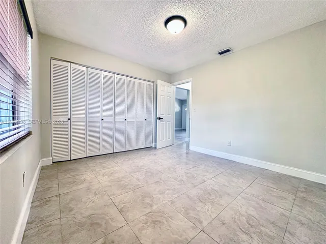 a bedroom with a large bed and a potted plant