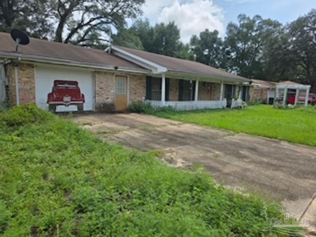 a front view of a house with a garden and trees