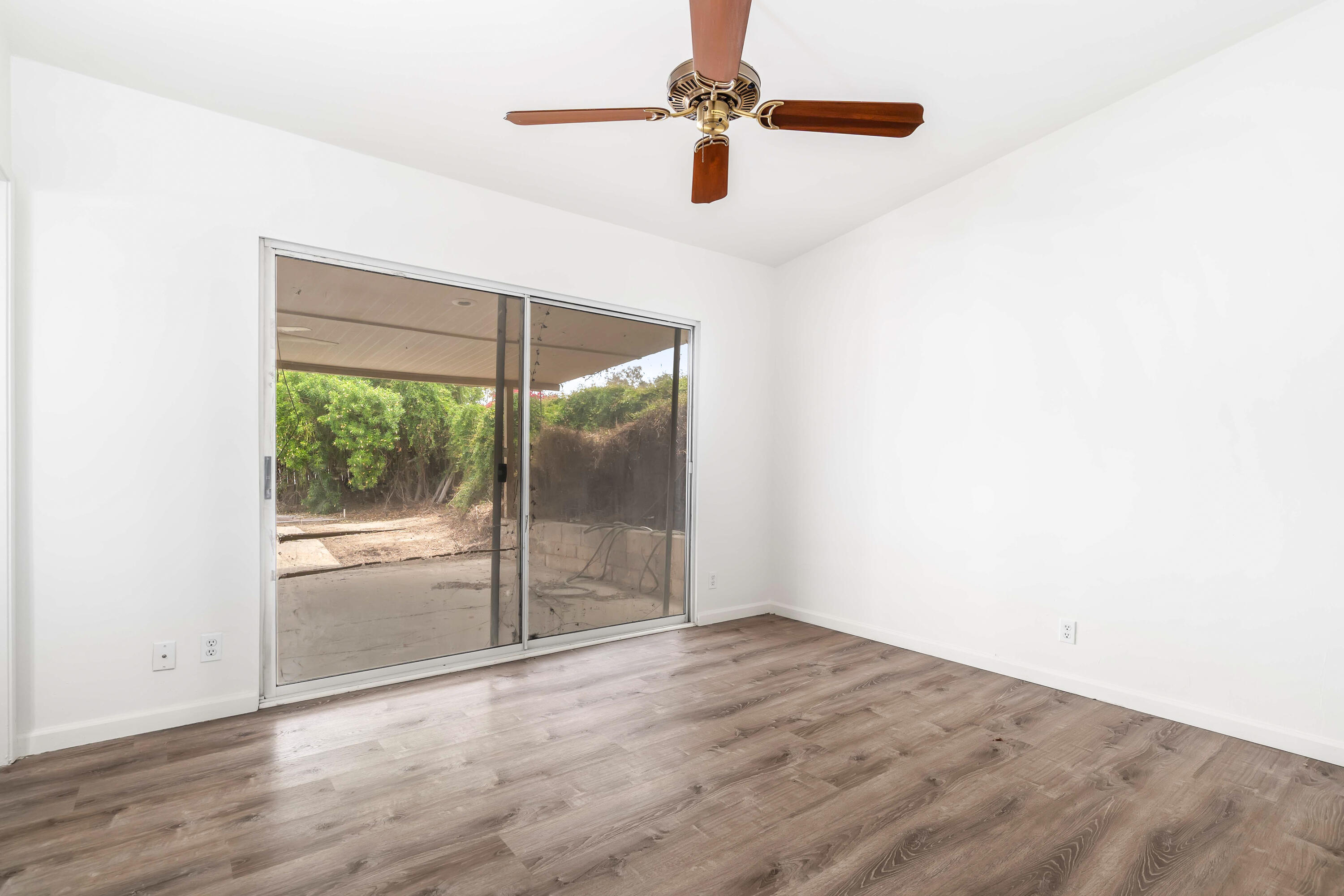 43831 Joshua Road Palm Desert, CA 92260 - Photo 18 of 42 an empty room with wooden floor fan and windows