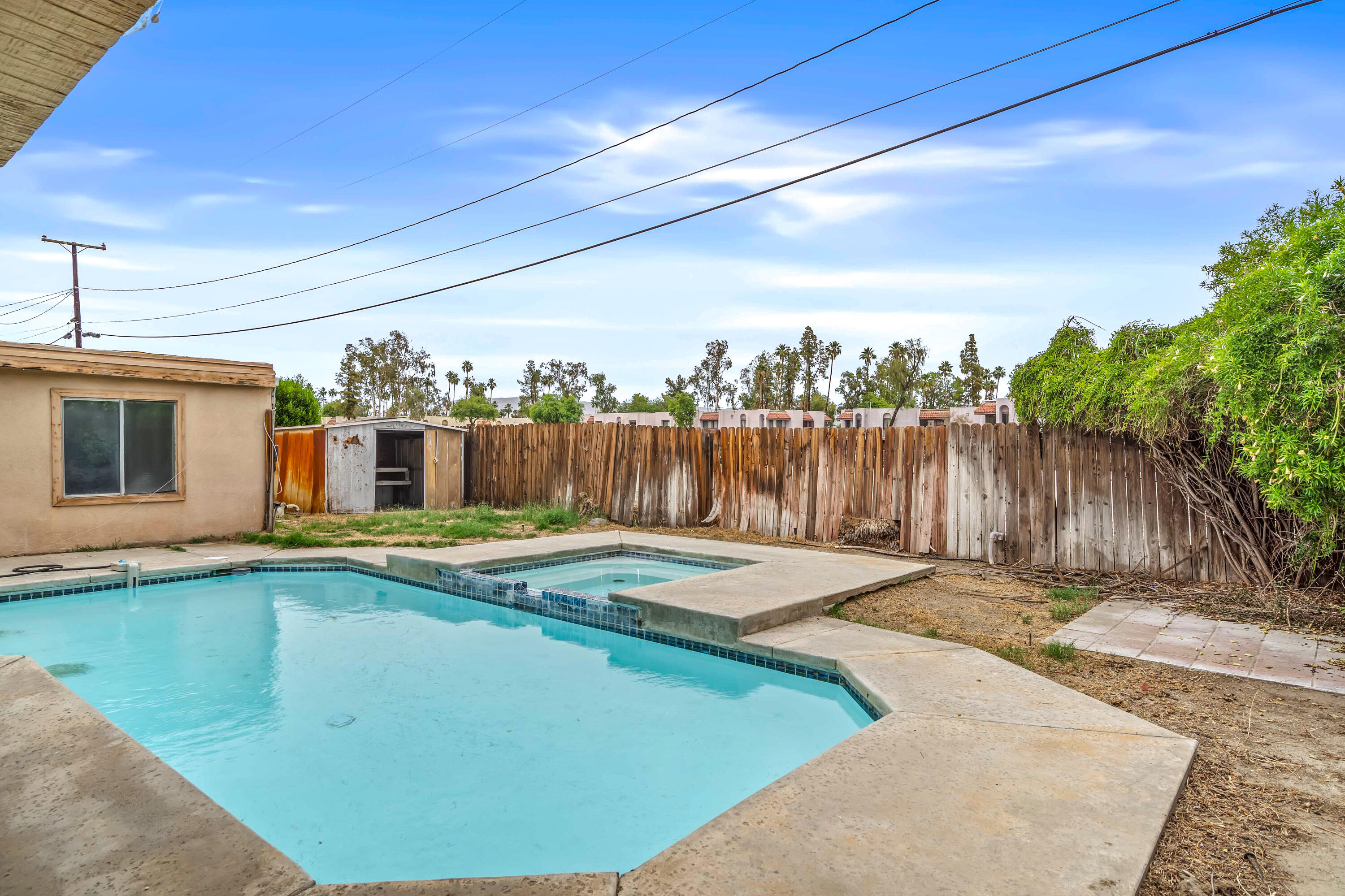 43831 Joshua Road Palm Desert, CA 92260 - Photo 24 of 42 a view of a backyard with table and chairs a barbeque and wooden fence