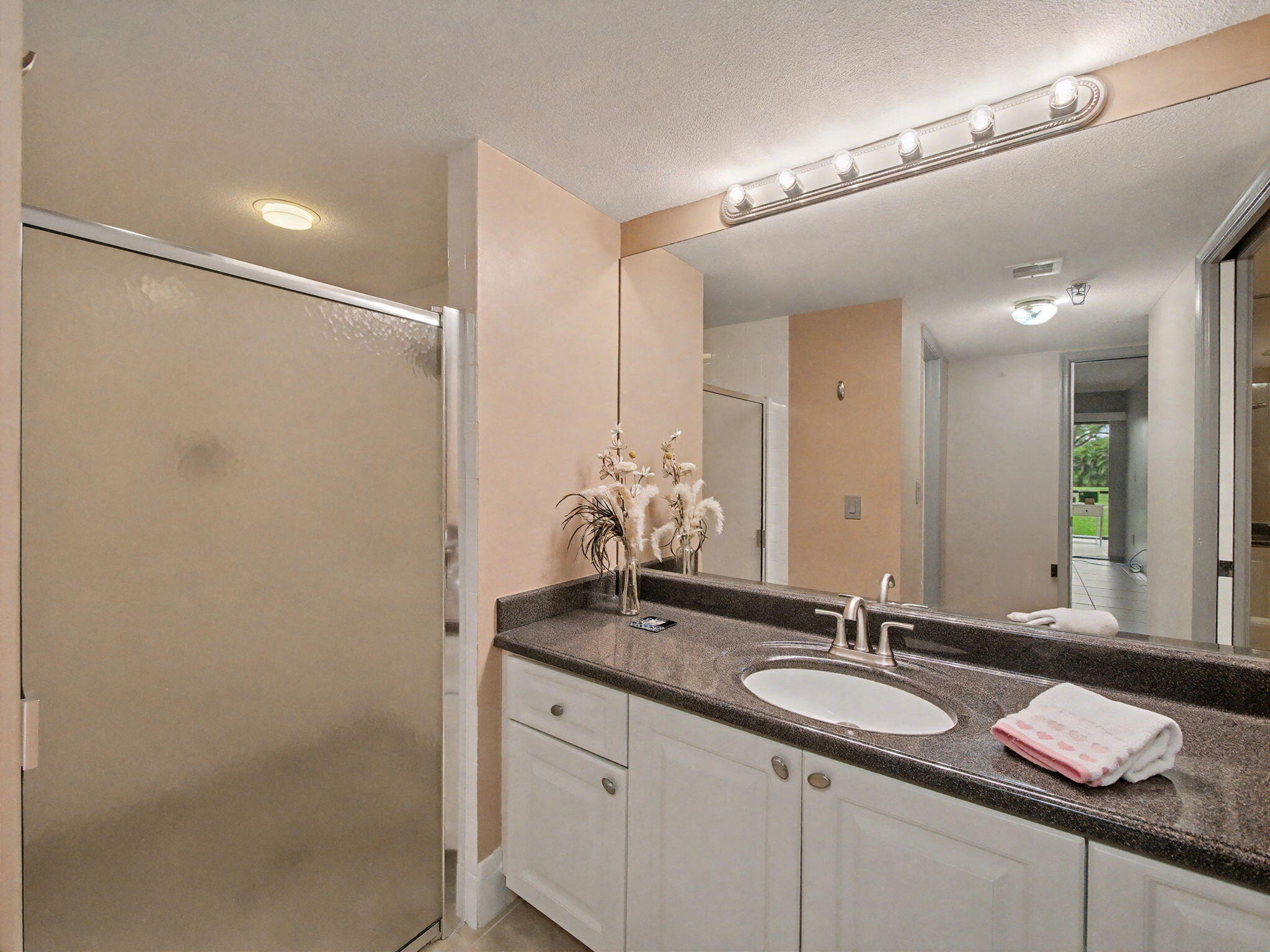 9220 Southwest 14th Street, Unit 3103 Boca Raton, FL 33428 - Photo 17 of 27 a bathroom with a granite countertop sink and a mirror