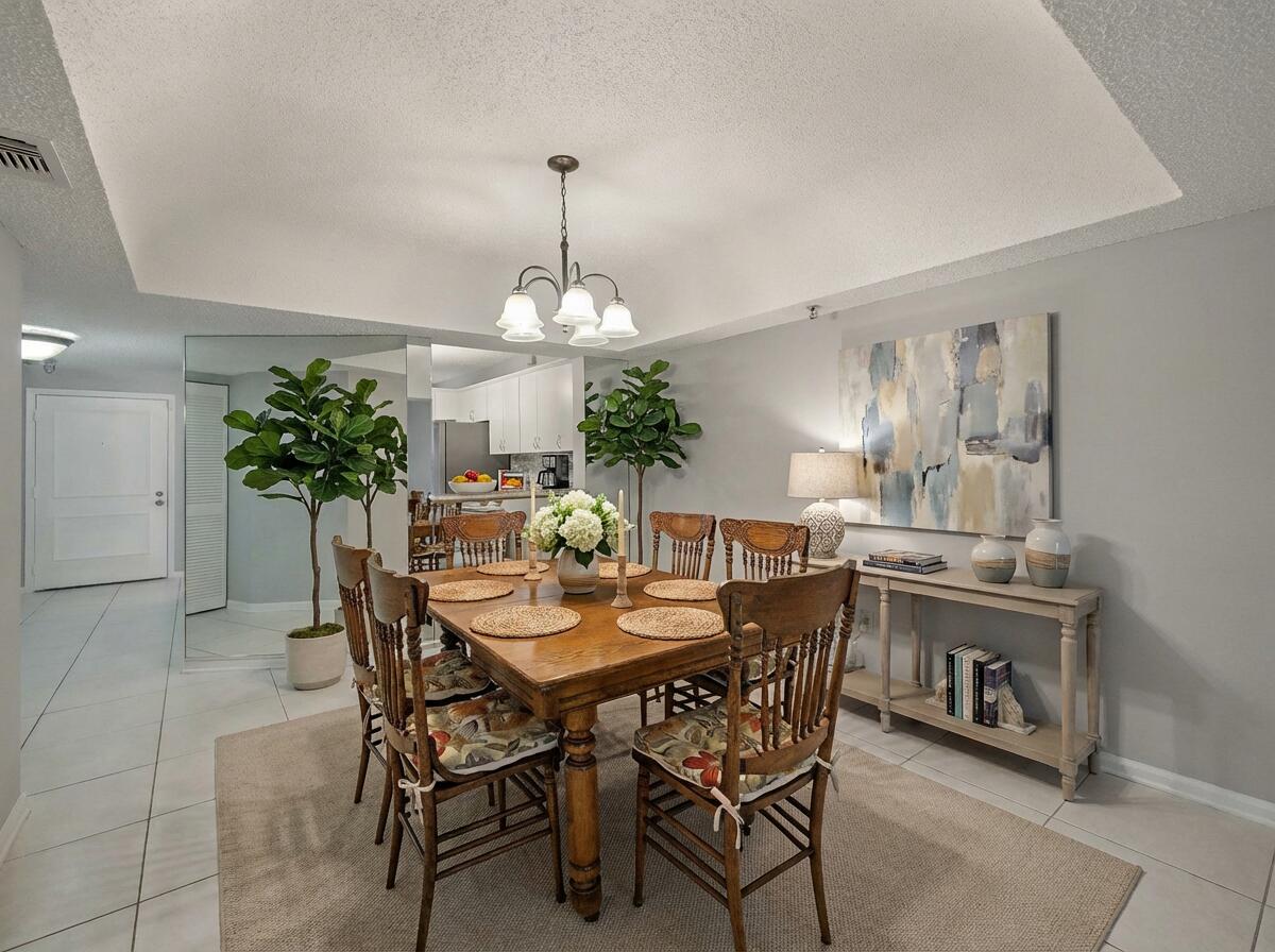 9220 Southwest 14th Street, Unit 3103 Boca Raton, FL 33428 - Photo 7 of 27 a view of a dining room with furniture and chandelier