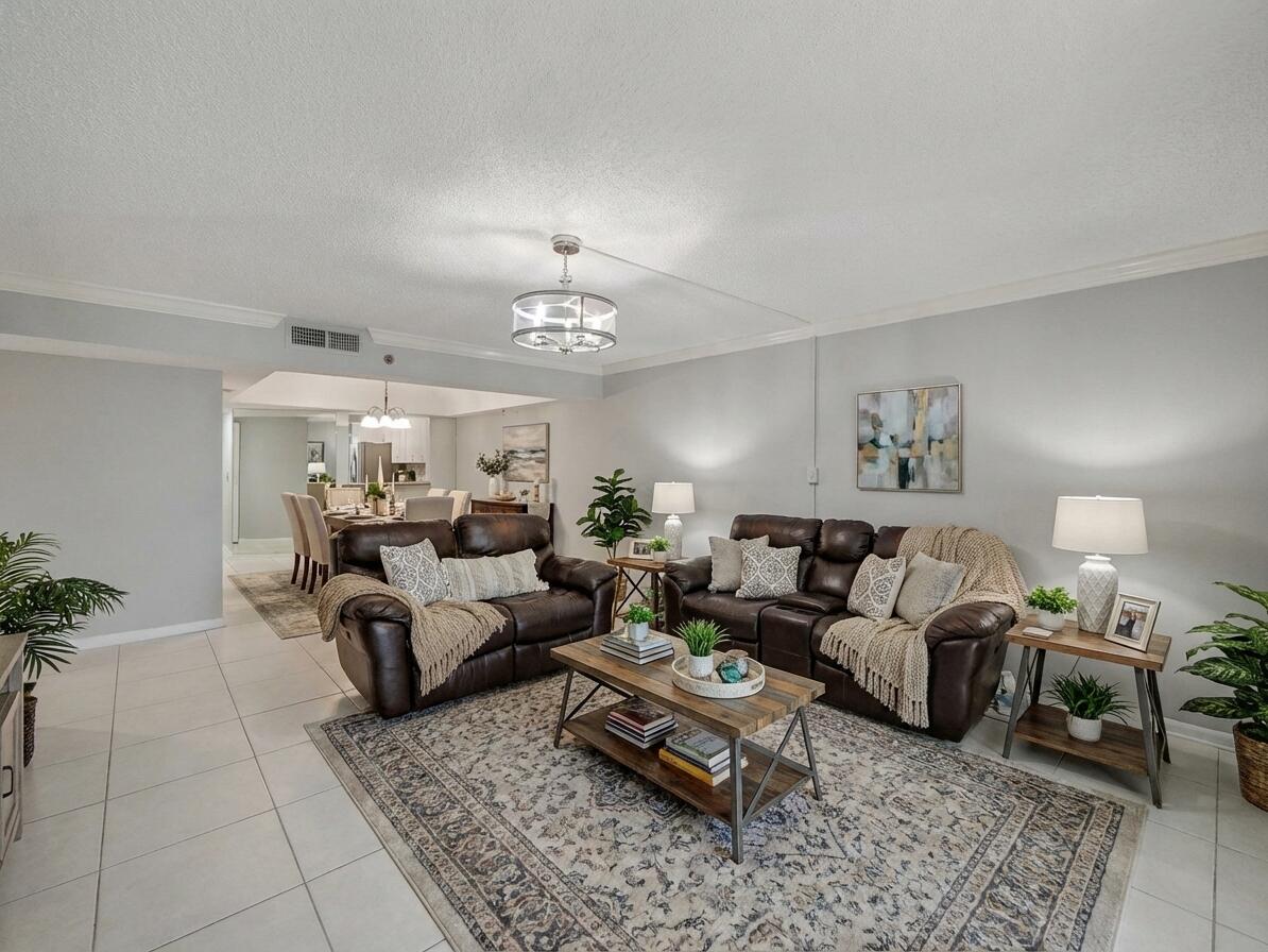 9220 Southwest 14th Street, Unit 3103 Boca Raton, FL 33428 - Photo 9 of 27 a living room with furniture and a chandelier