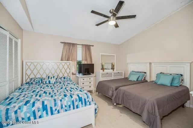 a bedroom with two beds and a chandelier