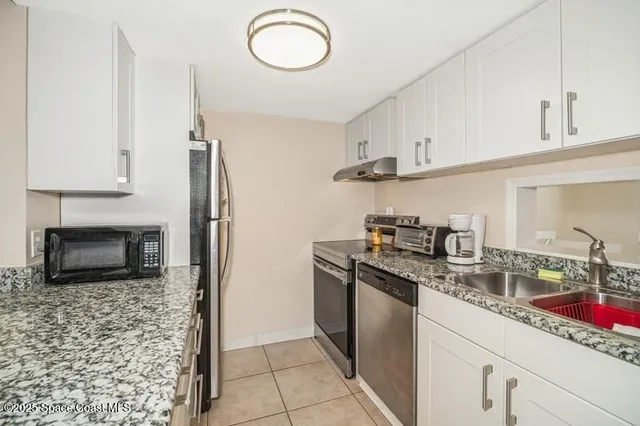 a kitchen with stainless steel appliances granite countertop a sink a stove and a refrigerator