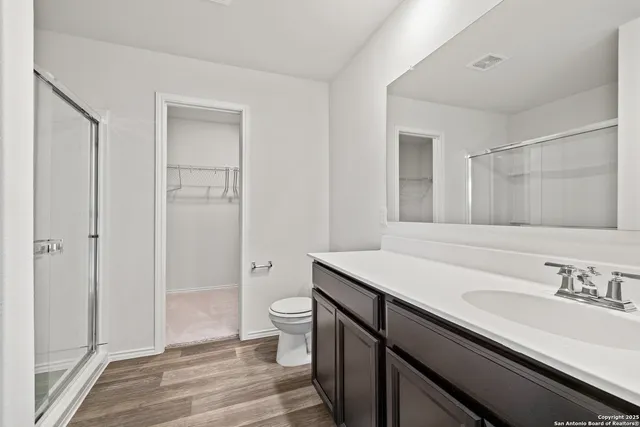 a bathroom with a sink a toilet and shower