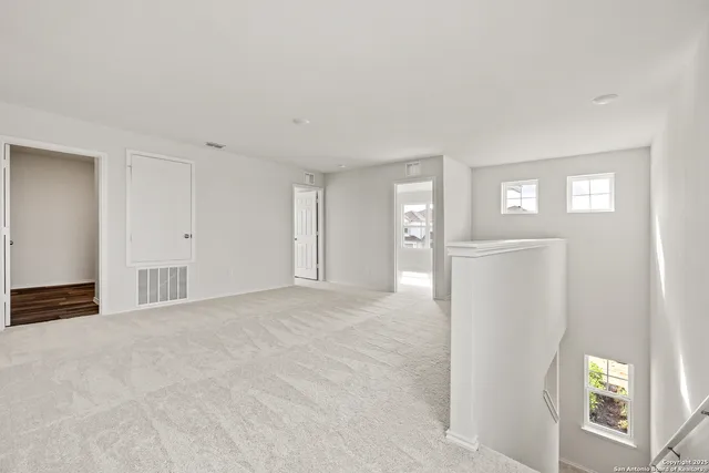 a view of an empty room with window and bathroom