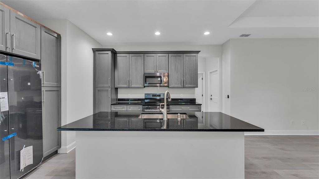 1640 Pearce Road Winter Haven, FL 33881 - Photo 8 of 33 a kitchen with stainless steel appliances granite countertop a sink a stove and a refrigerator