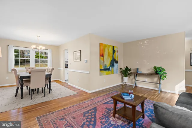 a view of a dining room with furniture a chandelier and wooden floor