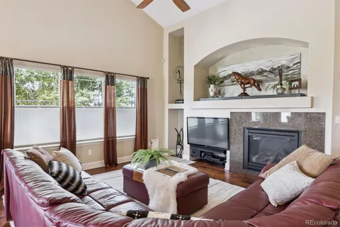 a living room with furniture a large window and a fireplace