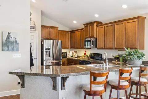 a kitchen with stainless steel appliances granite countertop a refrigerator and microwave