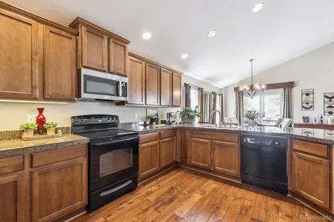 a kitchen with granite countertop cabinets stainless steel appliances and a sink