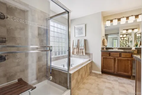 a spacious bathroom with a tub sink and mirror
