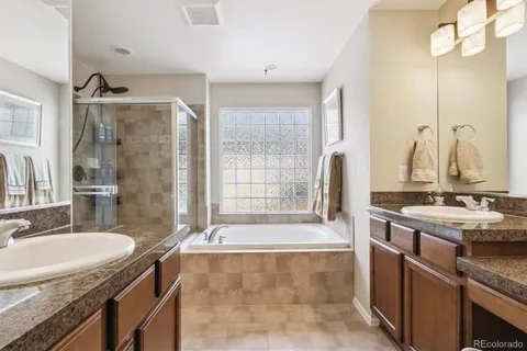 a bathroom with a granite countertop tub sink and mirror