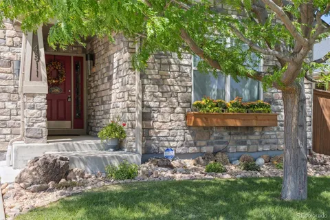 a view of a backyard with plants and large tree