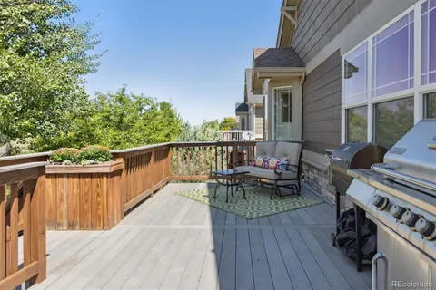 a view of a patio with couches chairs and wooden floor