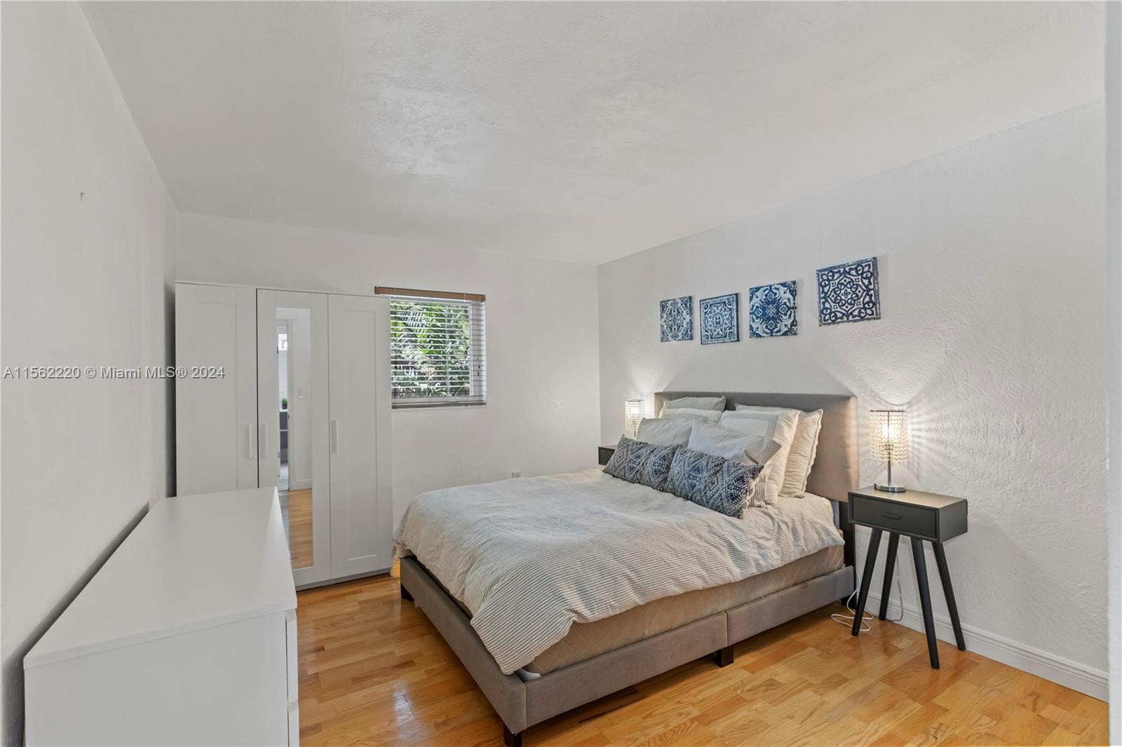 8617 Southwest 68th Court, Unit 24 Pinecrest, FL 33156 - Photo 13 of 22 a bedroom with a bed and painting on the wall
