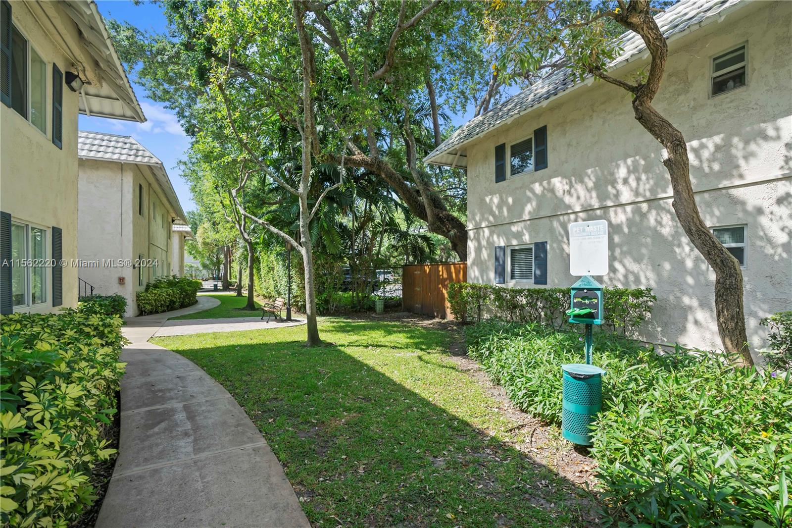 8617 Southwest 68th Court, Unit 24 Pinecrest, FL 33156 - Photo 21 of 22 a view of a white house next to a yard with big trees