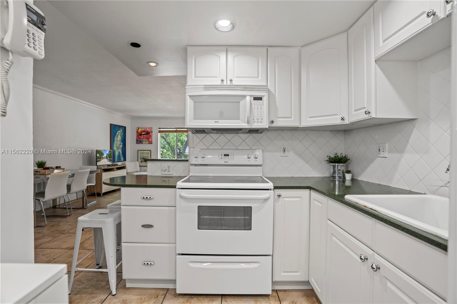 8617 Southwest 68th Court, Unit 24 Pinecrest, FL 33156 - Photo 9 of 22 a kitchen with cabinets appliances a sink and a counter top space
