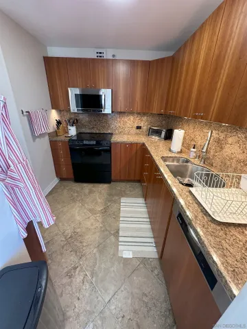 a kitchen with stainless steel appliances granite countertop a sink stove and oven