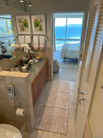 a bathroom with a sink mirror toilet and next to a large window