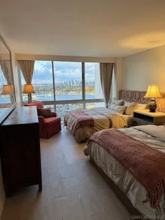 a bedroom with two beds and a large window