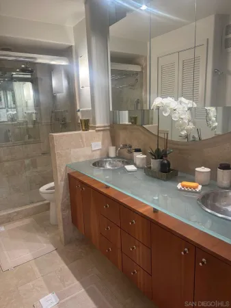 a bathroom with a granite countertop sink a toilet and a mirror