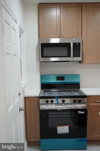 a stove top oven sitting inside of a kitchen